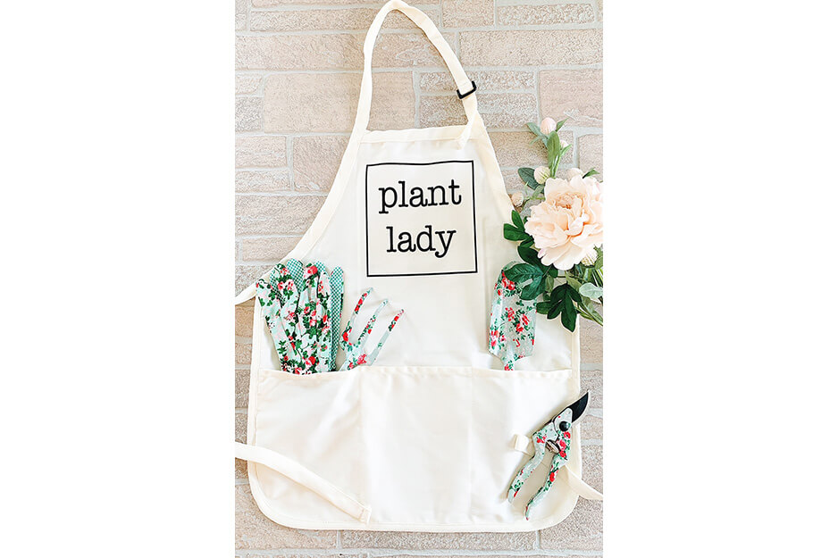 A white apron printed with the words "plant lady" by Wendy and Wander using its Roland DG VersaStudio BT-12 DTG printer.