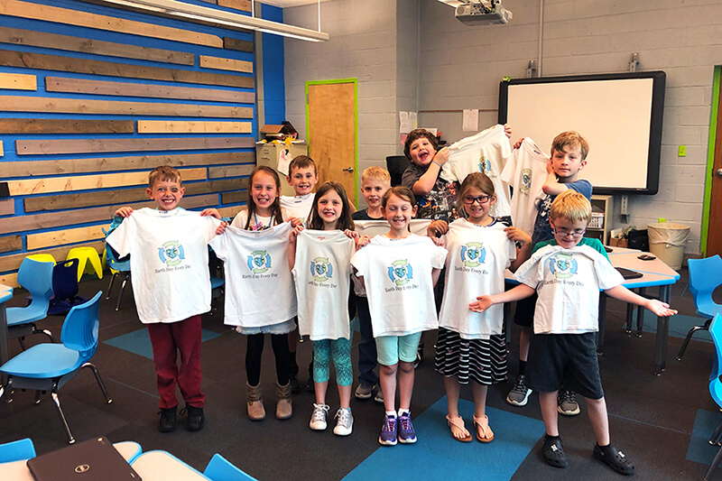 Burrell Elementary students hold the t-shirts they made on the Roland BT-12 direct-to-garment printer